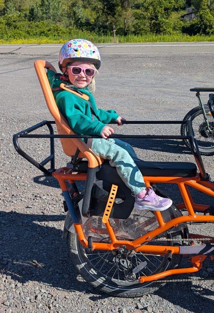 Child riding in a rear-mounted child seat on a RadWagon e-bike rental at Tioga Wilds